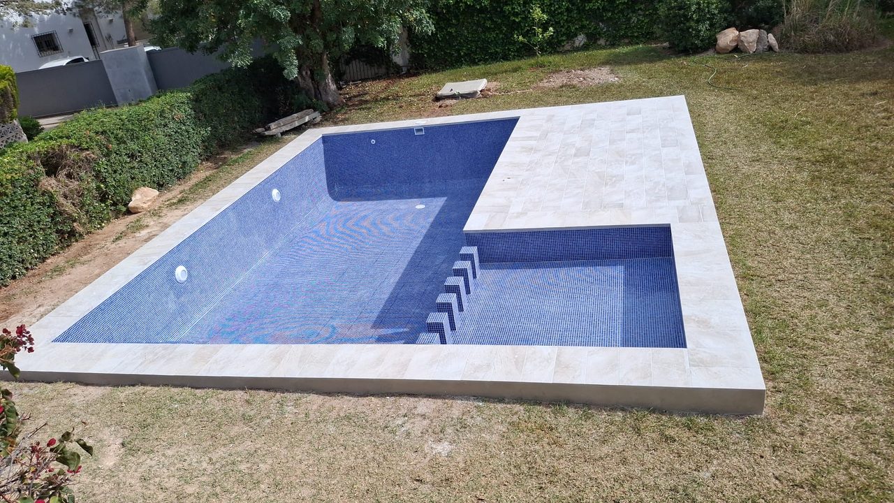 Swimming pool with built-in steps and blue mosaic tiling